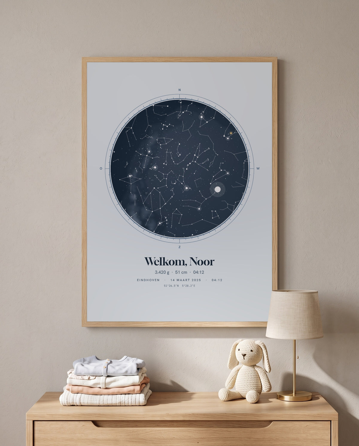 Geboorteposter met de sterrenhemel en de tekst 'Welkom, Noor', boven een commode in de babykamer