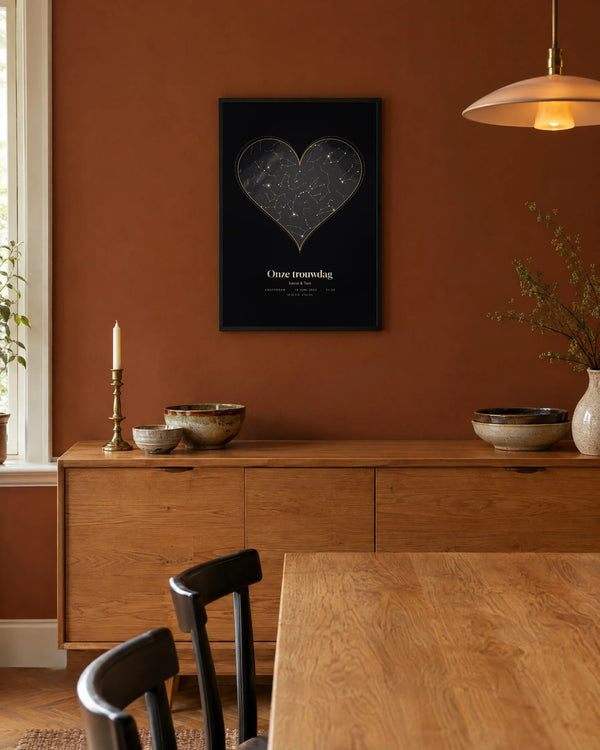 Sterrenkaart in hartvorm, stijl Zwart & goud, met de tekst 'Onze trouwdag', boven een dressoir in de eetkamer (sfeerfoto gemaakt met AI)